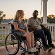 Hannah and Marcus, an interabled couple laughing on a porch swing